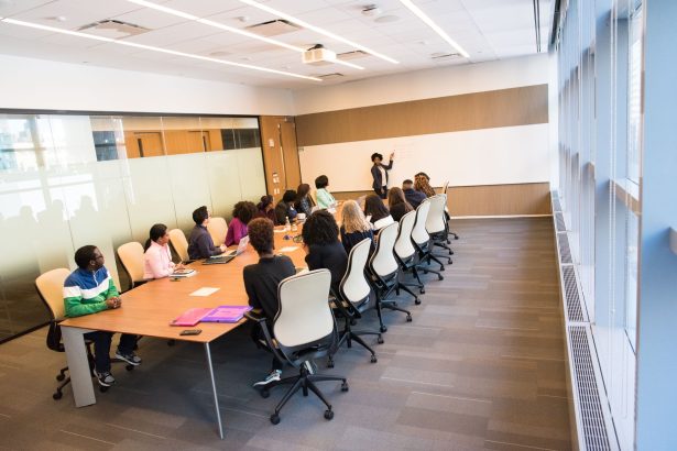 Grupo diverso de profissionais reunido em uma sala de conferências, participando de uma atividade de colaboração e formação.