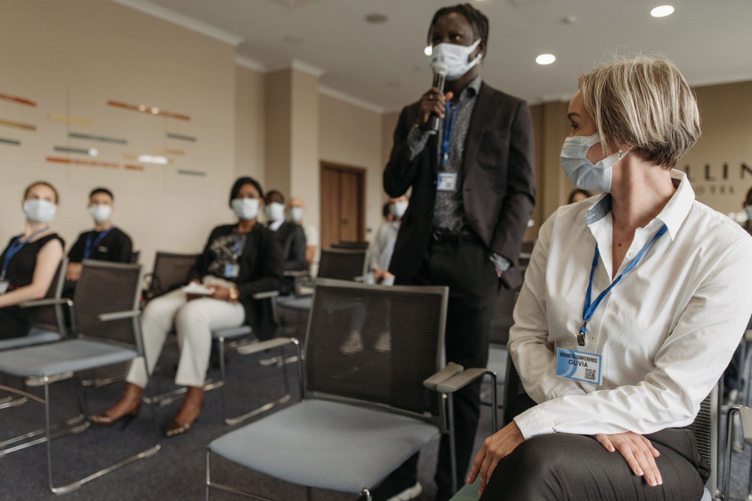 Profissionais de saúde usando máscaras participam de uma reunião em ambiente interno.