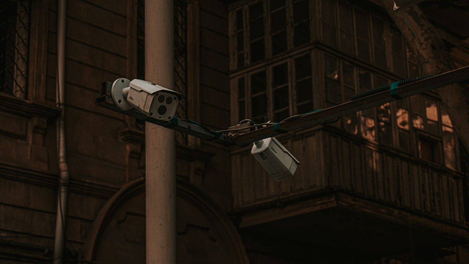 Câmeras de segurança instaladas em um poste, voltadas para uma área urbana.