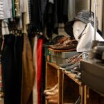 Interior de uma loja de roupas com peças, calçados e acessórios expostos.