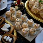 Seleção de canapés e aperitivos variados dispostos para uma celebração festiva.